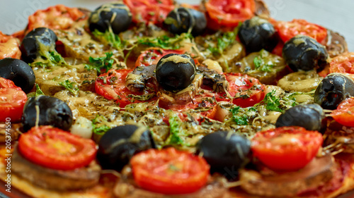 Veggie pizza with mushrooms, cherry tomatoes, black olives and herbs close up. Pizza background