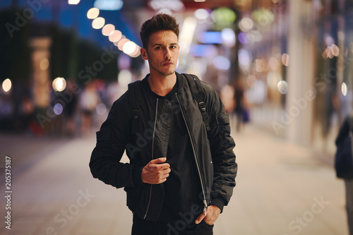 Portrait of stylish man on night city background pose to camera