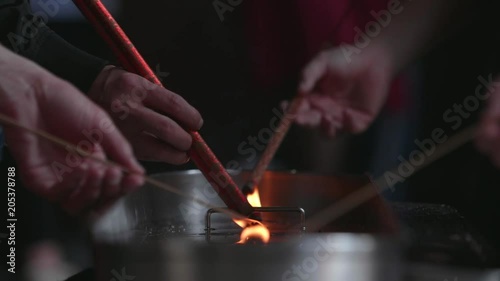 Unidentified person burning the incense sticks in slow motion
