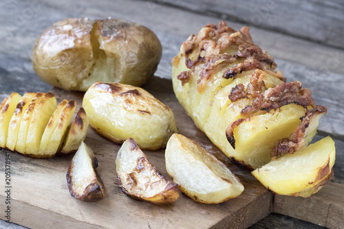 Baked potatoes of different kinds located on a wooden background in rustic style close-up