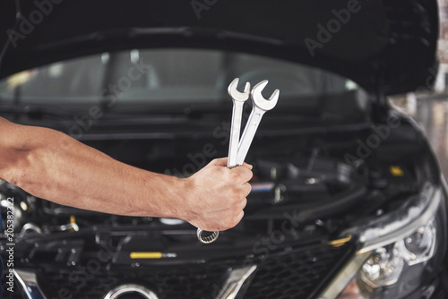 Hands of car mechanic with wrench in garage © standret