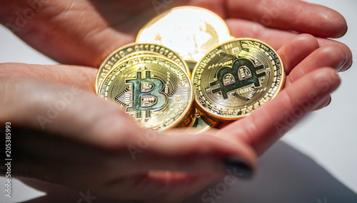 Golden Bitcoin coins in hand, natural sunlight