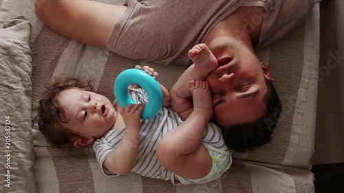 Young tired father sleep near a little child in a bed