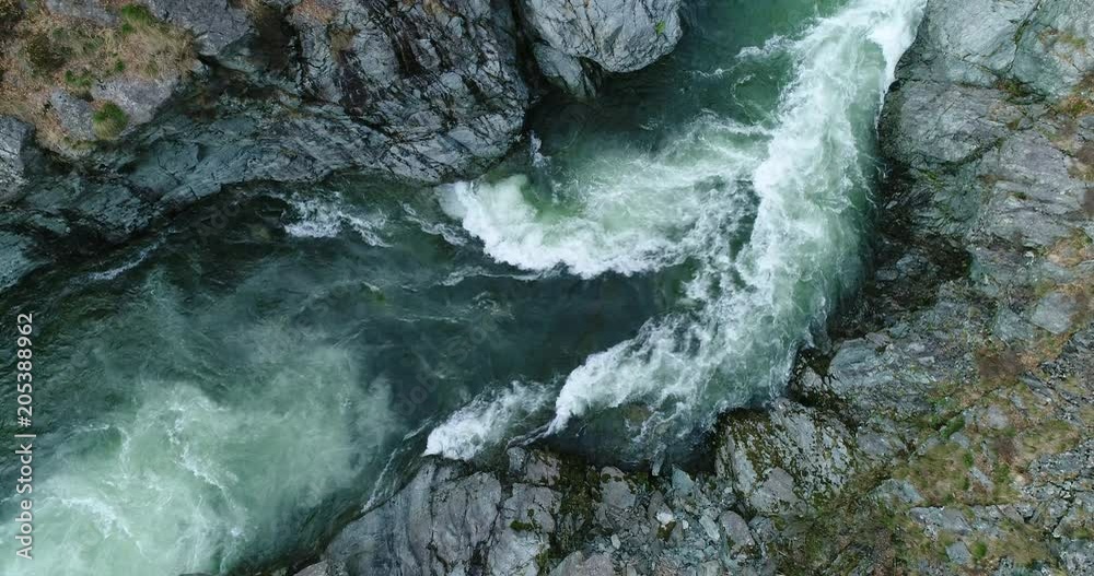 Mountain river flowing in a canyon in springtime, bird view, perspective from above.