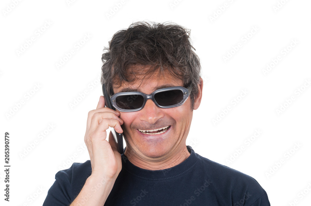 Excited man in sunglasses talking by smartphone on white background