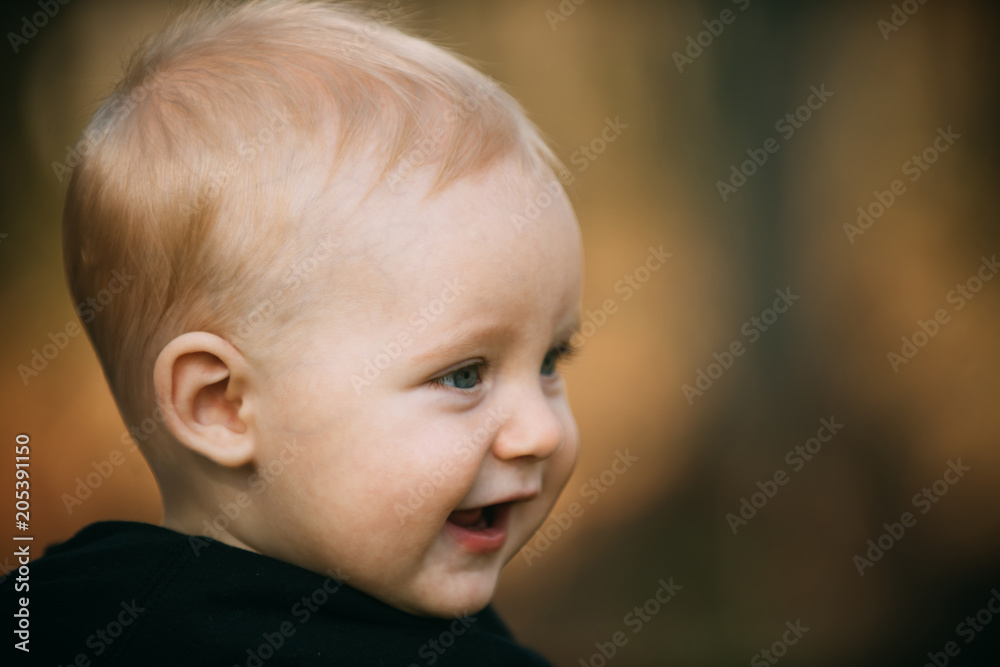 Child with blond hair smile outdoor, childhood. Child boy smiling on blurred nature, copy space Child with blond hair smile outdoor, childhood. Child boy smiling on blurred nature, copy space