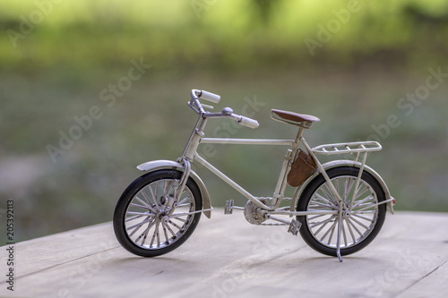 Bicycle toy models on wooden floor with sunshine