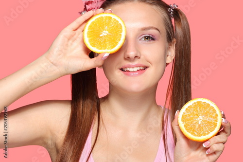 Young girl posing with halves of orange
