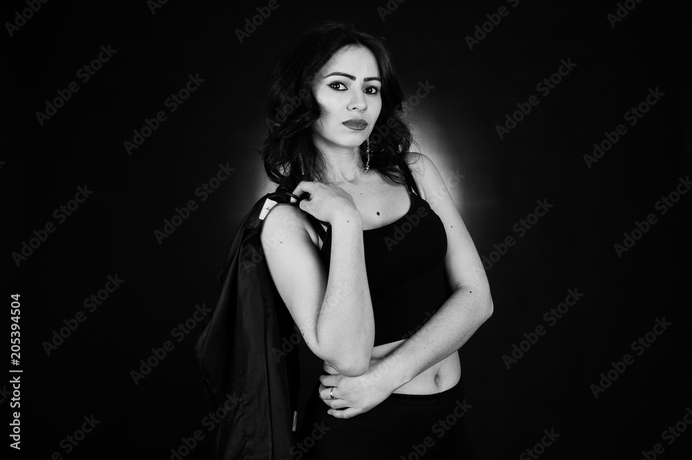 Studio portrait of sexy brunette girl in black leather jacket against black background. Studio portrait of sexy brunette girl in black leather jacket against black background.