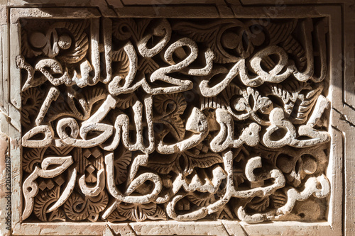 Stone wall with detail of traditional arabian calligraphy photo