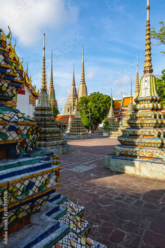 Buildings and many ornate chedis at the Wat Pho temple complex in Bangkok during a sunny day . landmark of Thailand photo