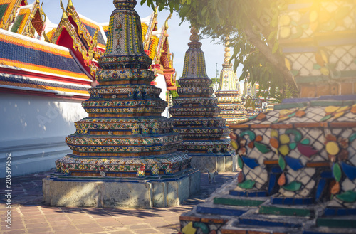 Buildings and many ornate chedis at the Wat Pho temple complex in Bangkok during a sunny day . landmark of Thailand