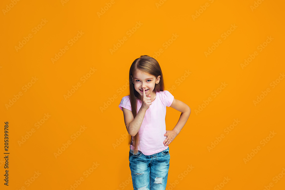 The young teen girl whispering a secret behind her hand The young teen girl whispering a secret behind her hand