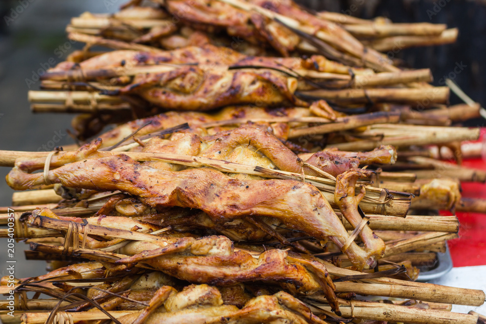 Close up roasted Chicken with bamboo stick Thailand Street Food Bangkok Thailand