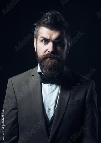 Fashion hipster wear bow tie with formal jacket. Man with beard and mustache on unshaven face. Bearded man with stylish hair. Skincare and grooming concept. Barber and hair salon © Volodymyr