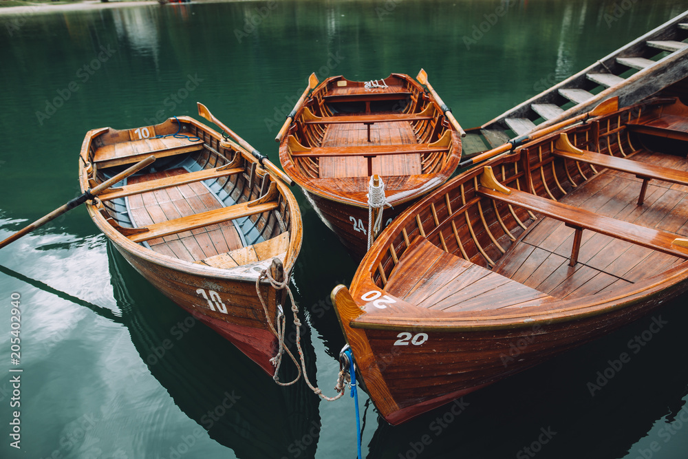 Many boats lying by a beautiful lake in the alpine mountains. the lake is called Lago di braies and is the most beautiful