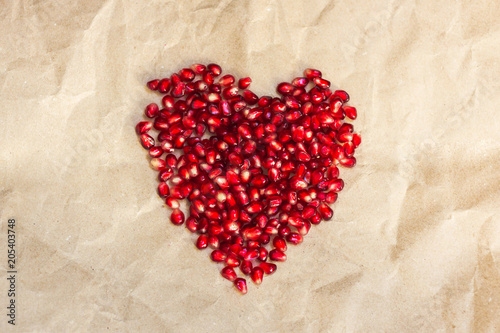 Pomegranate. Fresh raw seeds. Heart shape.