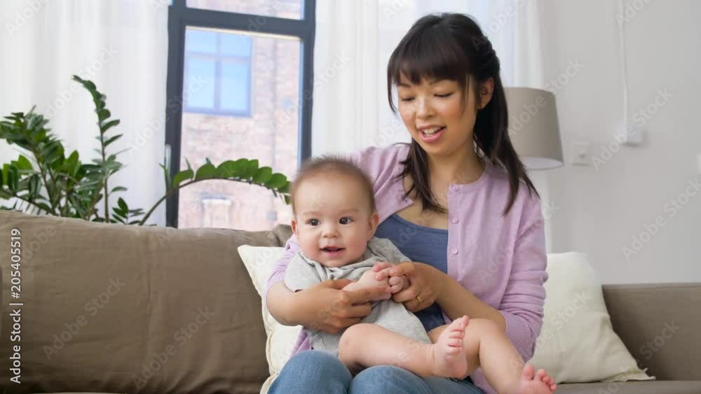 family and motherhood concept - happy smiling young mother with little baby boy at home family and motherhood concept - happy smiling young mother with little baby boy at home