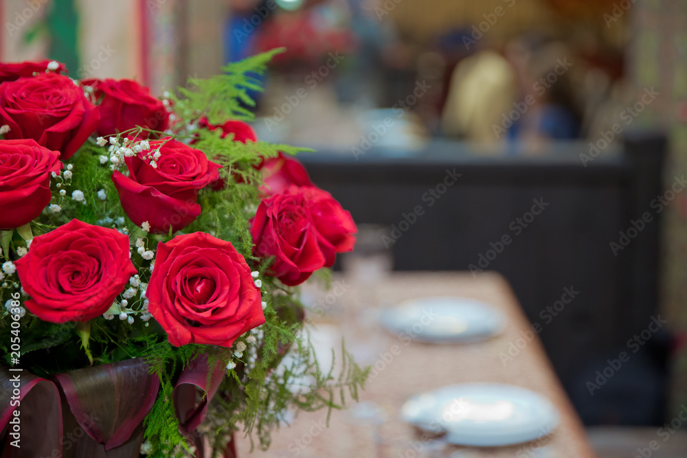 Obraz premium Beautiful red roses in a round box. Peach roses in a round box. Roses in a round box on a white wooden background. Romantic red roses in a small gift box white round space for the logo