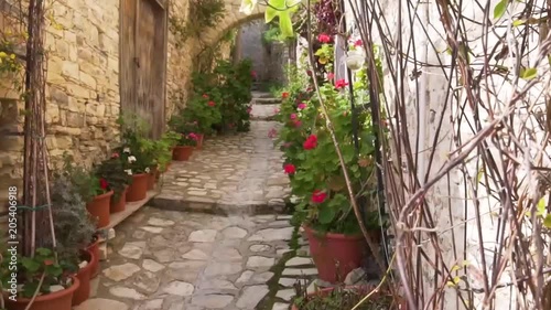 Lefkara street with flowering plants and stone arch, Cyprus 