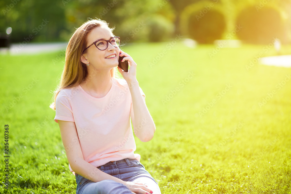 girl with glasses talking on the phone outdoors. copy space. girl with glasses talking on the phone outdoors. copy space.