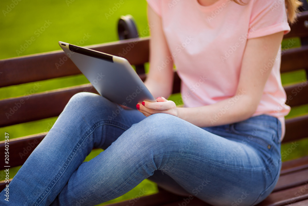 Naklejka premium Girl holding tablet in the Park. close up