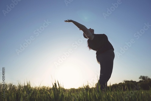 Body positive, yoga, confidence, freedom. Overweight woman practicing yoga outdoors. Obesity, wellness outdoor activity and health