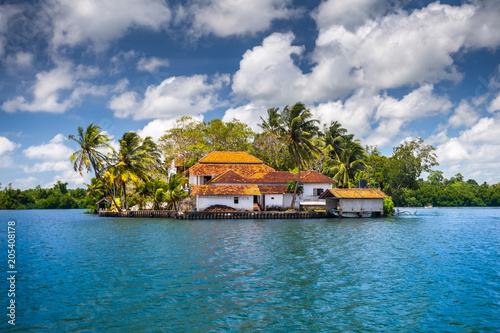 The small peninsula with the traditional buildings surrounded by the tropical plants. Idyllic place for the accommodation and relax. Balapitiya. South-western Sri Lanka. photo