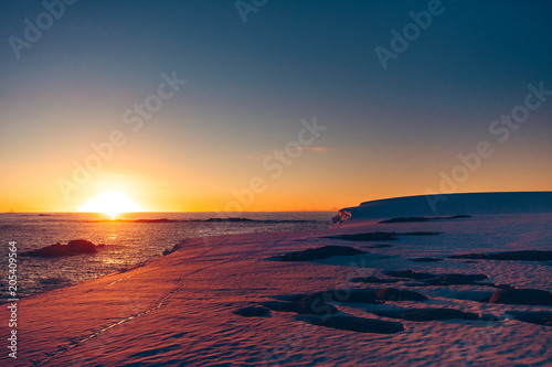 The polar sunset sunrise that was shot during the extreme expedition to the Vernadsky Research Base. Stunning snow landscape the icy Antarctic surface and Pacific Ocean.