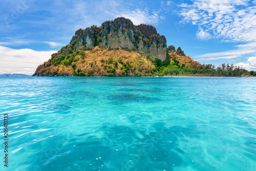 Fototapeta Naklejka Na Ścianę i Meble -  Spectacular scenery the tropical island with the limestone cliffs covered with the vegetation in the crystal clear ocean next to the exotic Phi Phi Islands, the Kingdom of Thailand. Paradise image.