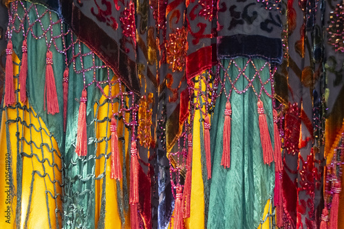 Brightly colored and saturated boho background with layers of fabrics and tassels and net