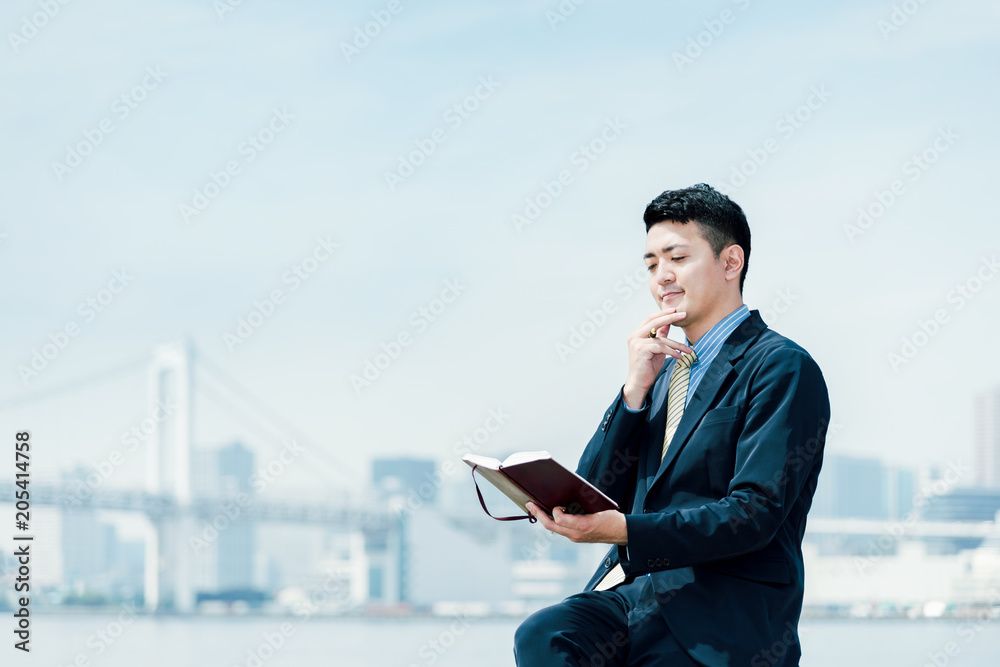 スケジュールを確認する男性・ビジネスイメージ