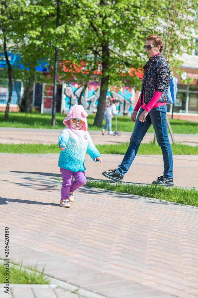 child walks with mom in sunglasses child walks with mom in sunglasses