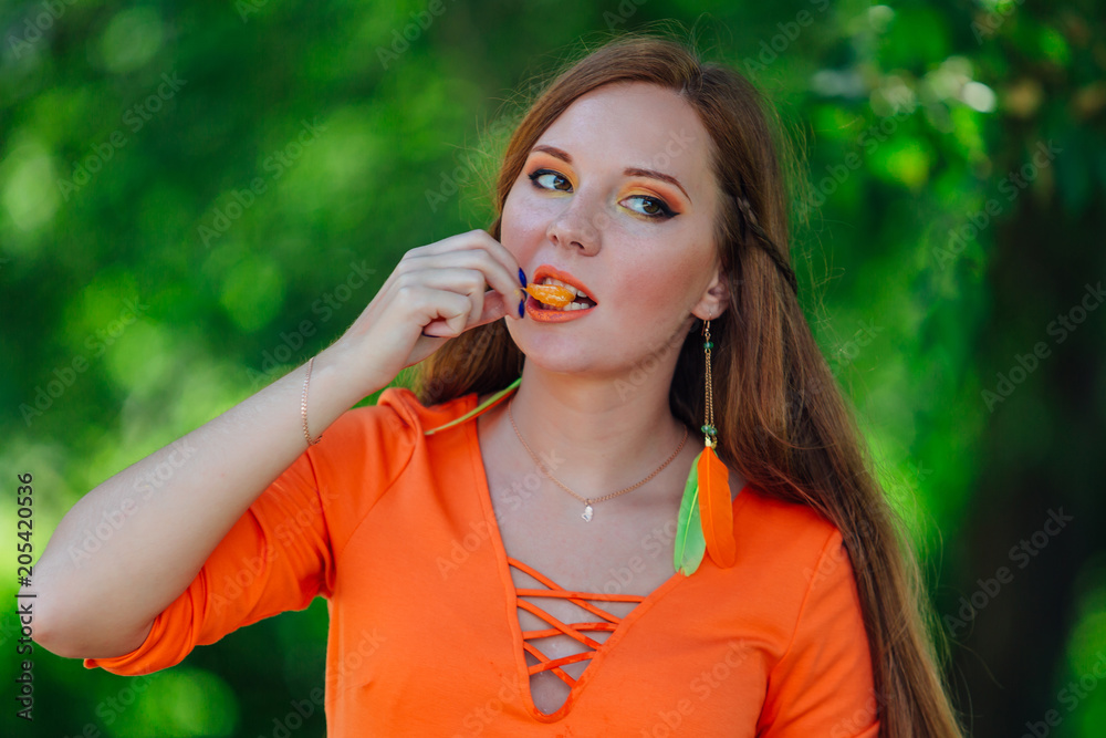 Portrait of pretty red hair woman with juicy delicious orange at summer green park. Portrait of pretty red hair woman with juicy delicious orange at summer green park.