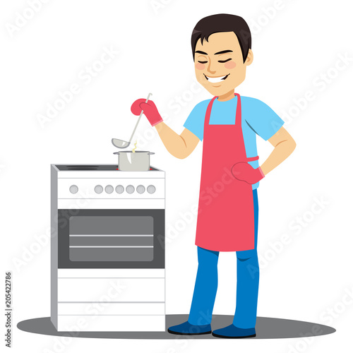 Young man cooking soup on electric kitchen stirring pot with ladle