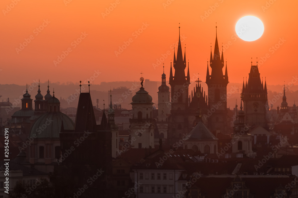 Twilight in historical city. Magical picture of tower with orange sun in Prague,