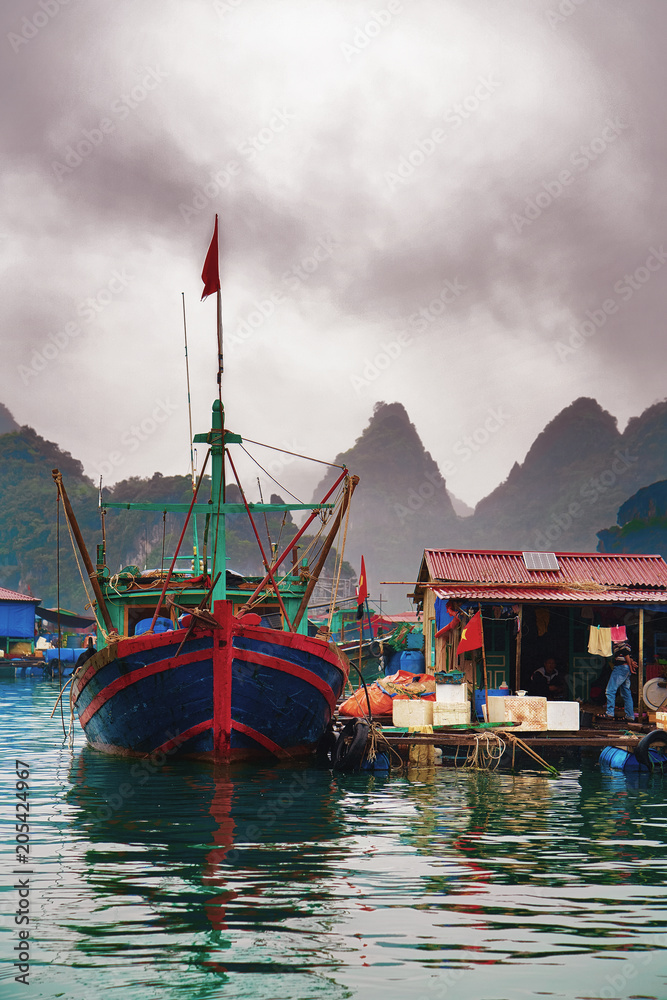 Ship at floating fishing village on Ha Long Bay