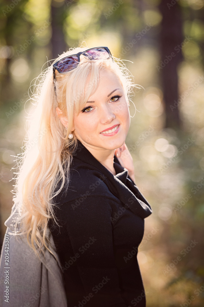 A young, blonde and smiling woman portrait on a sunny autumn day. A young, blonde and smiling woman portrait on a sunny autumn day.