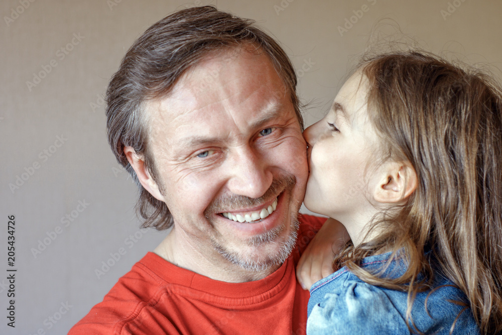 The daughter kissing father gently in cheek The daughter kissing father gently in cheek