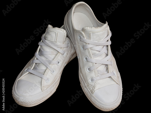 Closeup white trendy female leather sneakers isolated on the black background