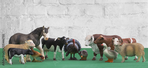 A group of farm animals stand in a circle on a green background