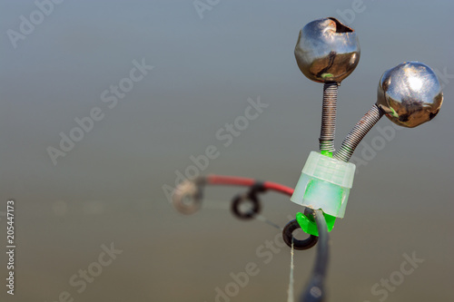 Pair of fishing bells. Bells will ring when the fish is hooked. Isolated on grey photo