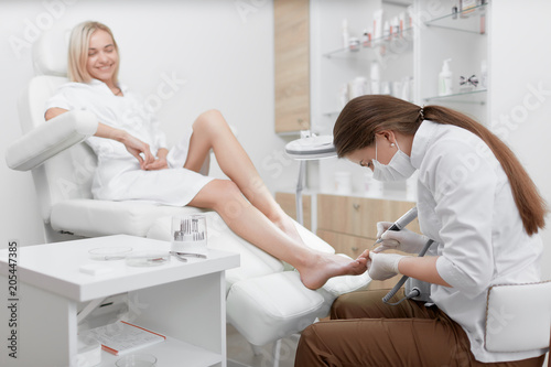 Podiatrist making procedure for smiling clients foot.