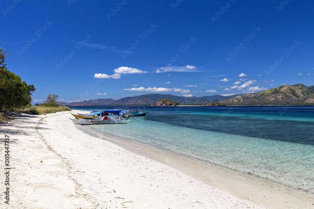 Boats docked on a beach in the Seventeen Island National Park, Flores, Indonesia.