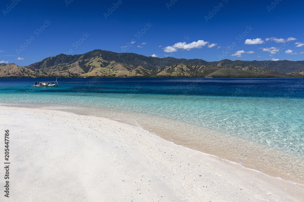A small boat near an empty beach in the Seventeen Island National Park, Flores, Indonesia.