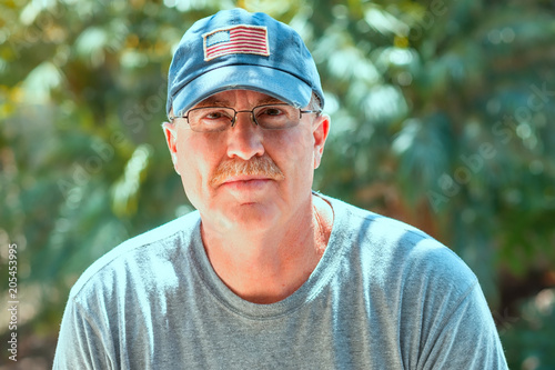 Senior male in baseball hat outdoors in natural light