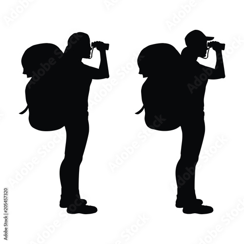 Isolated silhouette of a hiker girl looking through binoculars