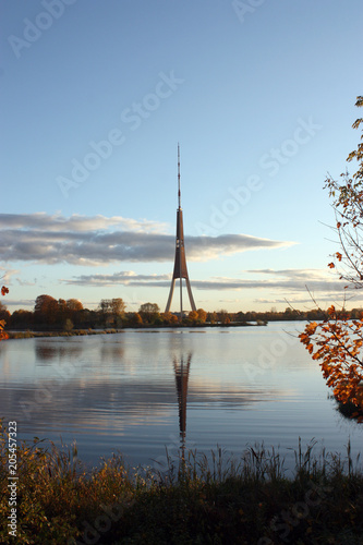 The tv tower is reflected in the water, in the evening