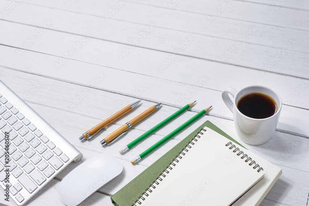 Wooden White office desk table with cup of coffee, Notebook, Pen on it. Wooden White office desk table with cup of coffee, Notebook, Pen on it.