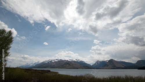 Grand Teton mountain range under cumulus clouds at Jackson Lake in the Grand Teton National Park in Wyoming United States photo